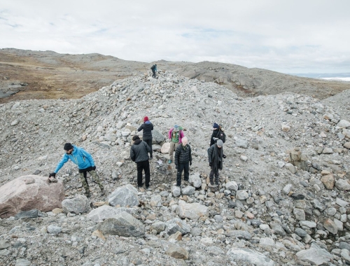 Several students walking over the Greenland tundra