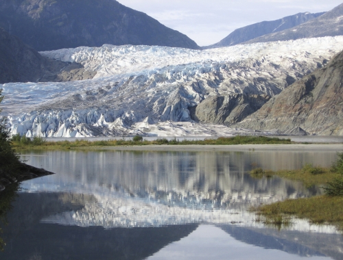 A photo of the Mendenhall Glacier in Alaska against the water